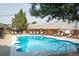 Beautiful, sunny swimming pool surrounded by lounge chairs and a well-maintained wooden fence at 6495 E Happy Canyon Rd # 163, Denver, CO 80237