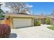 Charming brick home featuring an attached garage and a beautifully paved driveway under a sunny, blue sky at 2243 S Olive St, Denver, CO 80224