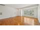 Spacious living room with gleaming hardwood floors, crisp white walls, and shuttered windows for ample natural light at 2243 S Olive St, Denver, CO 80224