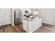 Modern kitchen featuring stainless steel appliances, an island, and wood flooring at 2958 Oxley St, Strasburg, CO 80136
