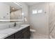 Modern bathroom features a sleek vanity, quartz countertops, and a stylish, lighted mirror at 2626 S Pennsylvania St, Denver, CO 80210