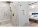 Elegant bathroom showcasing a marble-tiled walk-in shower with a built-in seat, plus a view of a bedroom at 2626 S Pennsylvania St, Denver, CO 80210