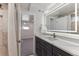 Bathroom featuring modern vanity, illuminated mirror, and marble-look tile at 2626 S Pennsylvania St, Denver, CO 80210