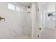 Updated bathroom featuring marble-look tile, shower niche, and updated fixtures at 2626 S Pennsylvania St, Denver, CO 80210