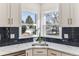 Modern kitchen with white cabinets, dark backsplash, undermount sink and beautiful countertop at 2626 S Pennsylvania St, Denver, CO 80210