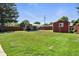 Spacious backyard with a covered parking area and a red shed, perfect for outdoor storage and activities at 25 S Winona Ct, Denver, CO 80219