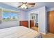 Comfortable bedroom with carpet, ceiling fan, large window, and mirrored closet at 25 S Winona Ct, Denver, CO 80219