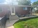 Exterior showcasing a charming brick home with green lawn and patio furniture at 25 S Winona Ct, Denver, CO 80219