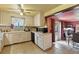 Well-lit kitchen featuring tile floors and countertops, white cabinets, and view into the dining room at 25 S Winona Ct, Denver, CO 80219