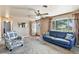 Inviting living room featuring a blue sofa and a cozy patterned armchair at 25 S Winona Ct, Denver, CO 80219