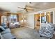 Cozy living room featuring a ceiling fan, plush carpet, and an entertainment center, perfect for relaxation at 25 S Winona Ct, Denver, CO 80219