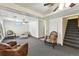 Living room with carpet, ceiling fans, and stairs leading upstairs at 25 S Winona Ct, Denver, CO 80219