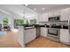 Modern kitchen with stainless steel appliances, black countertops, white cabinets, and an eat-in bar overlooking living area at 8884 Miners St, Highlands Ranch, CO 80126