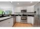 Modern kitchen with stainless steel appliances, black countertops, and white cabinets at 8884 Miners St, Highlands Ranch, CO 80126
