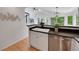 Modern kitchen with stainless steel appliances, black countertops, white cabinets, and eat-in bar at 8884 Miners St, Highlands Ranch, CO 80126