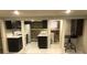 Basement kitchen featuring white appliances, stone accent wall and white tile floor at 2335 Stout St, Denver, CO 80205