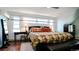 Bright bedroom with a large bed, colorful bedding, a bench, and ample natural light from multiple windows at 2335 Stout St, Denver, CO 80205