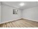 A bright bedroom featuring a window and light wood flooring at 5373 S Prescott St, Littleton, CO 80120