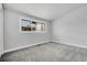 Bright bedroom featuring neutral walls, plush gray carpet, and a large window at 5373 S Prescott St, Littleton, CO 80120