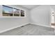 Bright bedroom featuring neutral walls, plush gray carpet, and a large window at 5373 S Prescott St, Littleton, CO 80120