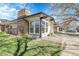 Charming brick home showcasing large windows, front lawn, lush landscaping and a tree with emerging spring buds at 5373 S Prescott St, Littleton, CO 80120