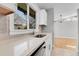 Close-up of a kitchen sink, quartz counters, and views to the living room with modern light fixture at 5373 S Prescott St, Littleton, CO 80120