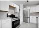 Bright kitchen featuring stainless steel appliances, modern cabinets, quartz counters, and stylish backsplash at 5373 S Prescott St, Littleton, CO 80120
