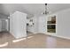 Bright living room featuring hardwood floors, neutral paint, and a modern light fixture near the front door at 5373 S Prescott St, Littleton, CO 80120