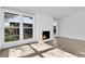 Bright living room with a cozy fireplace, large windows offering natural light, and newly installed hardwood floors at 5373 S Prescott St, Littleton, CO 80120