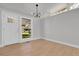 Inviting living room featuring light hardwood floors, modern lighting, and ample natural light from large windows at 5373 S Prescott St, Littleton, CO 80120