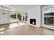 Spacious living room with brick fireplace, large windows that provides natural light, and beautiful hardwood floors at 5373 S Prescott St, Littleton, CO 80120