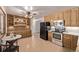 Well-lit eat-in kitchen with wood cabinets and stainless steel appliances at 779 Alkire St, Lakewood, CO 80401