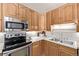 Functional kitchen with stainless steel appliances and wood cabinetry at 779 Alkire St, Lakewood, CO 80401