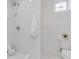 All-white bathroom with a tiled shower, toilet, and a small window for natural light at 15116 Lyons Ridge Dr, Morrison, CO 80465