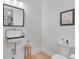 A clean, modern bathroom features white tile, a black framed mirror, and a toilet at 15116 Lyons Ridge Dr, Morrison, CO 80465