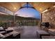 An outdoor covered patio has a grill, lounge seating, and beautiful views of the surrounding hills at 15116 Lyons Ridge Dr, Morrison, CO 80465