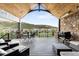 Expansive deck with stone accents and comfortable seating overlooks lush landscape, perfect for outdoor entertaining and relaxation at 15116 Lyons Ridge Dr, Morrison, CO 80465