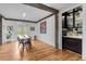 Well-lit dining space with wood floors, a bar, and views of the landscaped backyard at 15116 Lyons Ridge Dr, Morrison, CO 80465