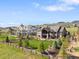 Beautifully landscaped home featuring a spacious lawn, mature trees, and a charming fence, perfect for outdoor enjoyment at 15116 Lyons Ridge Dr, Morrison, CO 80465