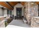 Inviting front entrance featuring a stone facade, a modern door, and a cozy seating area at 15116 Lyons Ridge Dr, Morrison, CO 80465