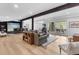 Spacious living room with hardwood floors, comfortable seating, and a bar area with a simulator at 15116 Lyons Ridge Dr, Morrison, CO 80465