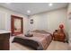 The bedroom features a striking mirror, light-colored walls, and a bed with a dark brown-and-pink-striped comforter at 3298 S Eudora St, Denver, CO 80222