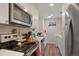 Modern kitchenette featuring stainless steel appliances, white cabinets, and ample countertop space at 3298 S Eudora St, Denver, CO 80222