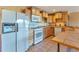 Kitchen featuring a white refrigerator, gas range, microwave, and wooden cabinets at 10550 Highway 73, Conifer, CO 80433