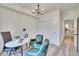Comfortable office space with modern chandelier, white walls, wood floors, closet, desk, and blue chairs at 1304 Snowberry # 102, Louisville, CO 80027