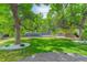 Picturesque backyard with mature trees, a manicured lawn, and a view of the home's exterior and deck at 7831 W 109Th Ave, Westminster, CO 80021