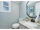 Powder room featuring vanity, toilet, framed mirror, and granite countertops at 7831 W 109Th Ave, Westminster, CO 80021
