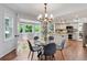 Dining area with a glass table, wood floors, chandelier, and view into the kitchen at 7831 W 109Th Ave, Westminster, CO 80021