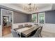 Stylish dining room featuring gray walls, white wainscoting, and a contemporary chandelier at 7831 W 109Th Ave, Westminster, CO 80021