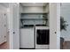 Laundry closet with stacked washer and dryer, shelving and hardwood floor at 7831 W 109Th Ave, Westminster, CO 80021